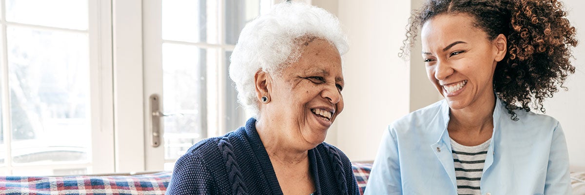 elderly woman and health care worker sharing a laugh